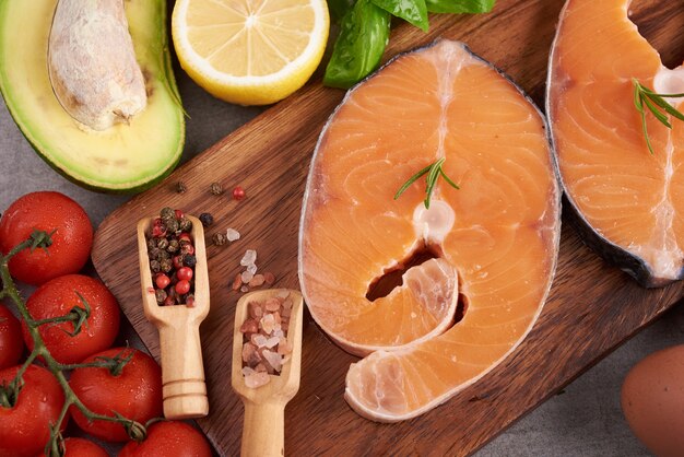 Вкусная порция свежего филе лосося с ароматными травами, специями и овощами - здоровое питание, диета или концепция приготовления. Концепция сбалансированного питания для чистой флекситарной средиземноморской диеты.