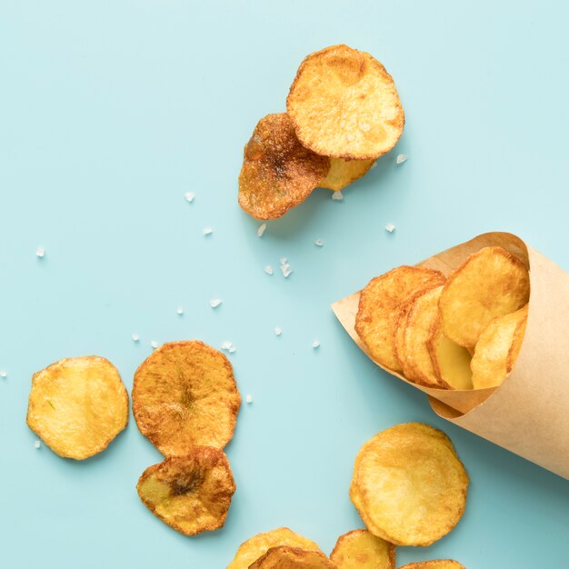 Delicious potato chips on blue background