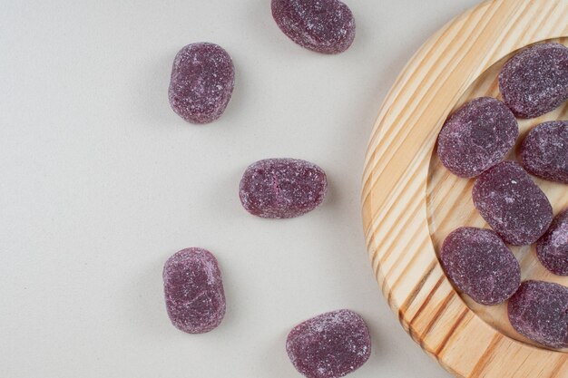 Delicious purple jelly candies on wooden plates