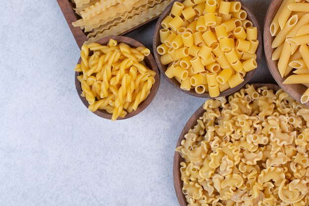 Delicious raw macaroni and vermicelli on wooden bowls