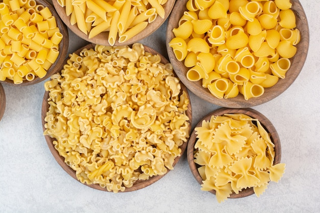 Delicious raw macaroni and vermicelli on wooden bowls