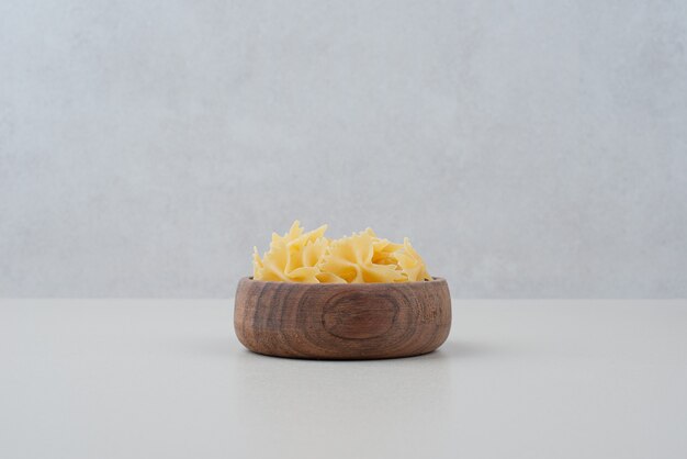 Delicious raw macaroni on wooden plate 