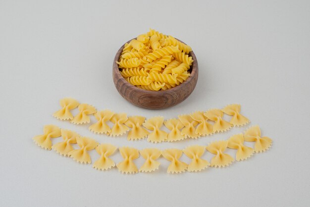 Delicious raw macaroni on wooden plate