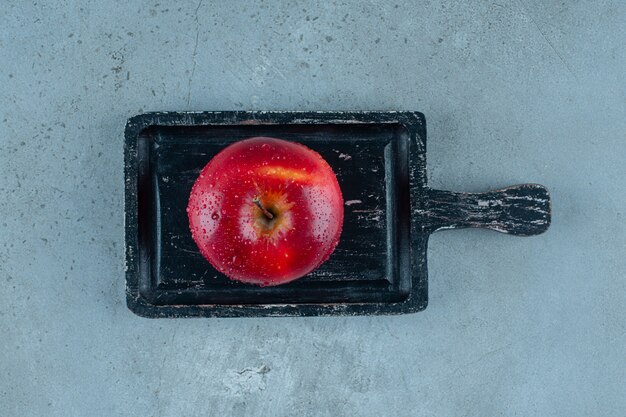 Delicious red apple on a board , on the marble background. High quality photo