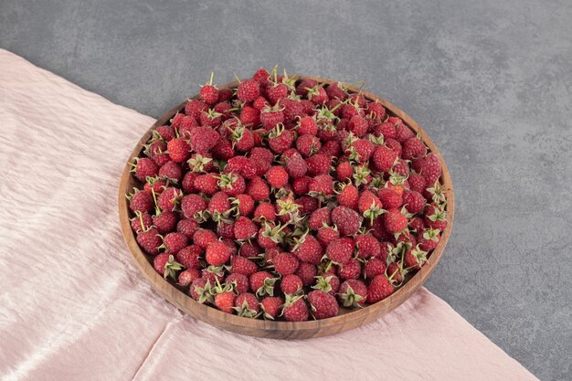 Delicious red raspberries on wooden plate. High quality photo