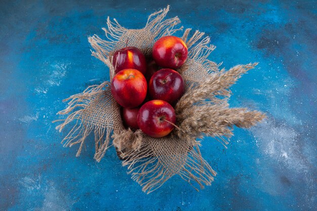 Delicious red shiny apples placed in wooden box.