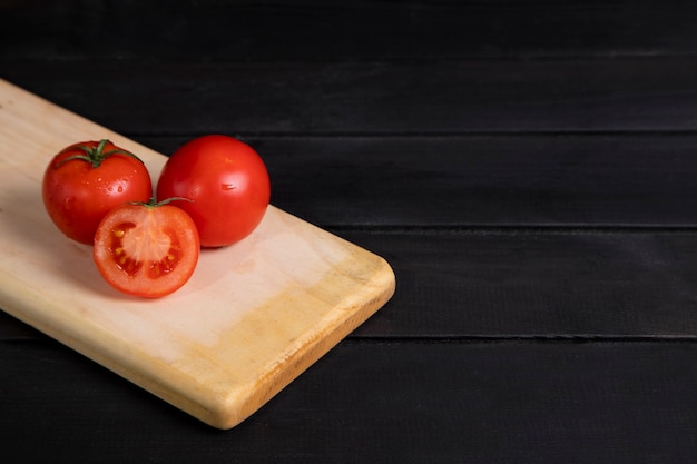 Delicious red tomatoes placed on wooden board. High quality photo