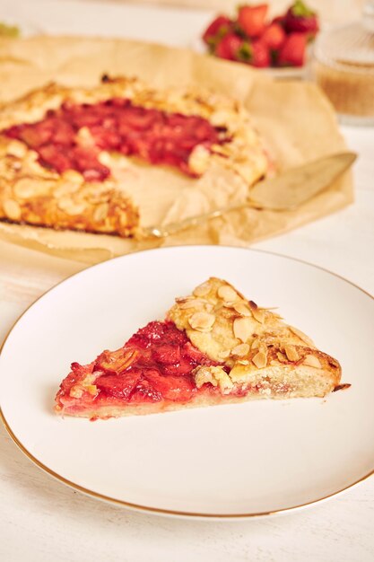 Delicious rhubarb strawberries gallate cake with ingredients on a white table