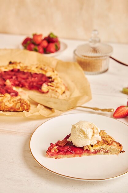 Delicious rhubarb strawberries gallate cake with ingredients on a white table