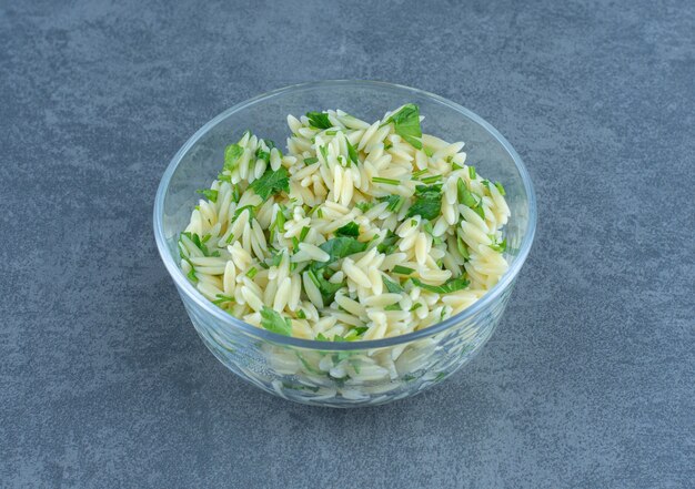 Delicious rice with greens in glass bowl.