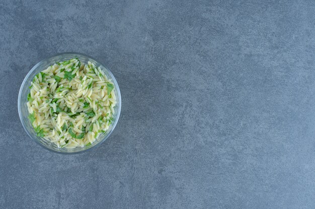 Delicious rice with greens in glass bowl.