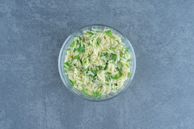 Delicious rice with greens in glass bowl. 