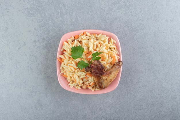분홍색 그릇에 구운 날개가 달린 맛있는 쌀.