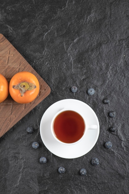 お茶と木の板においしい熟した富有柿