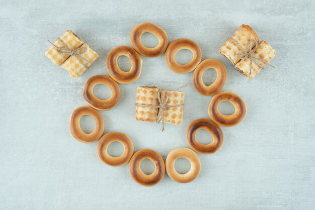 Delicious round cookies with waffles in rope on white background. High quality photo