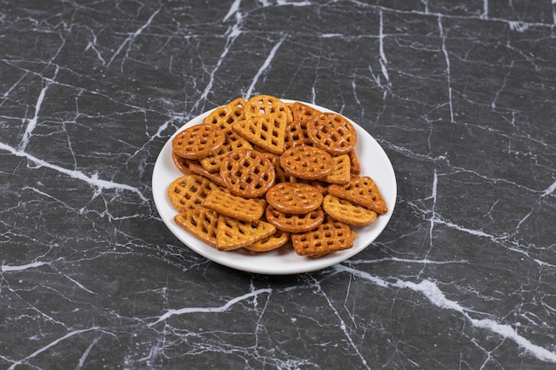 Free photo delicious salty crackers on white plate.