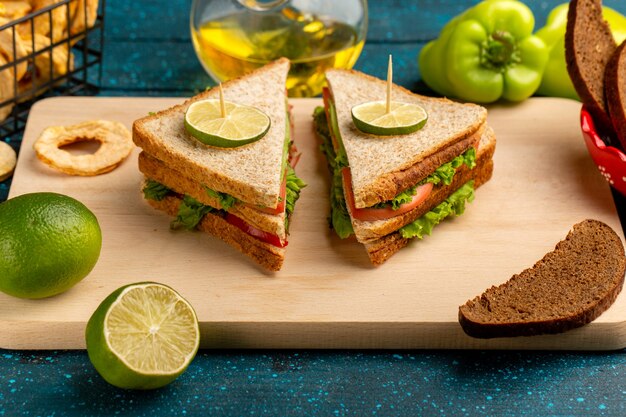 delicious sandwich with green salad tomatoes and ham on blue