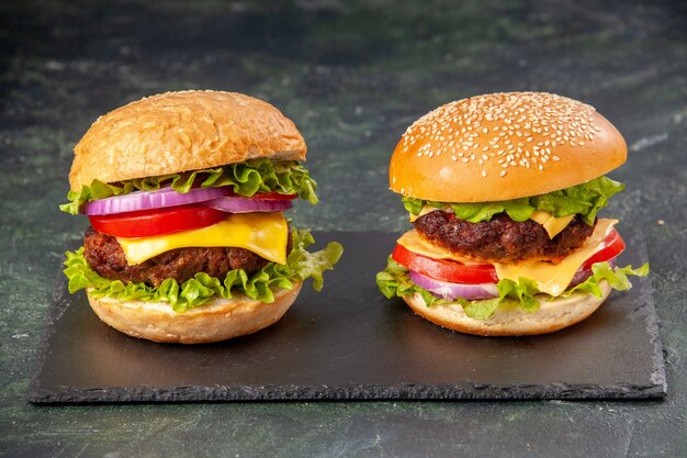 Delicious sandwiches on black board on dark mix color surface