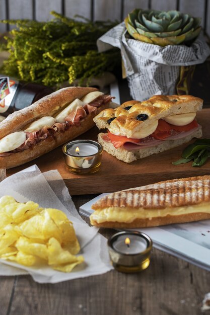 美しく装飾された木製のテーブルの上のおいしいサンドイッチとジャガイモ