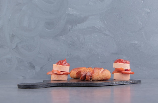 Foto gratuita salsiccia deliziosa, con ketchup sul tagliere, sulla superficie di marmo
