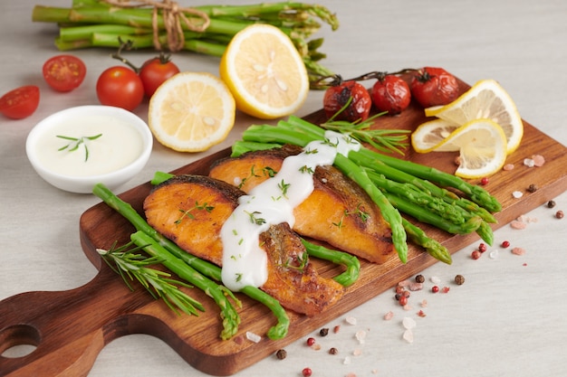 Delicious seasonal green asparagus and sliced smoked salmon on rustic plate