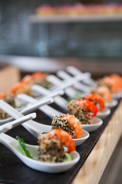 Delicious Snacks with Shrimps in White Spoons