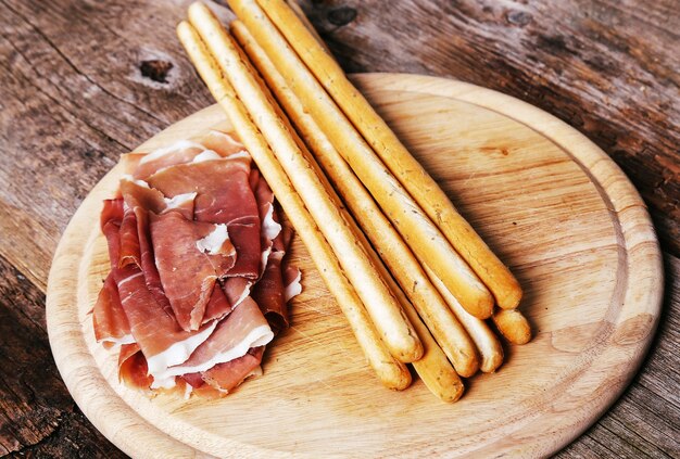 Delicious snacks on wooden board