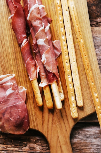 Delicious snacks on wooden board