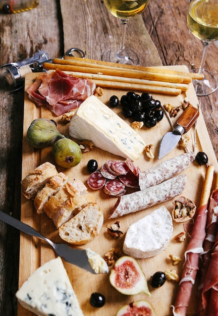 Delicious snacks on wooden board