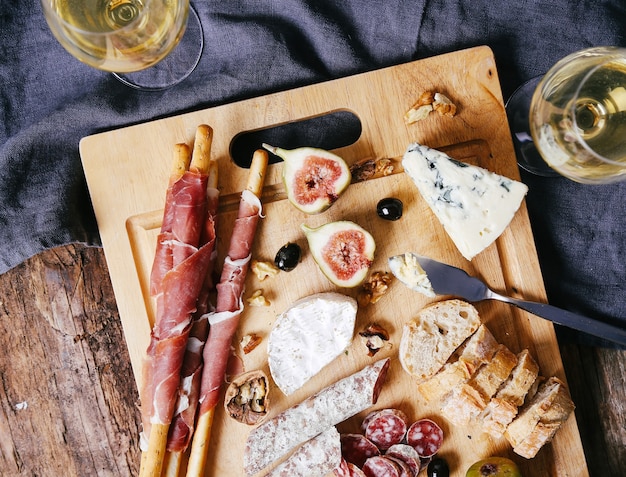 Delicious snacks on wooden board