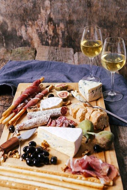 Delicious snacks on wooden board