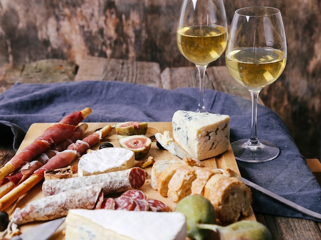 Delicious snacks on wooden board