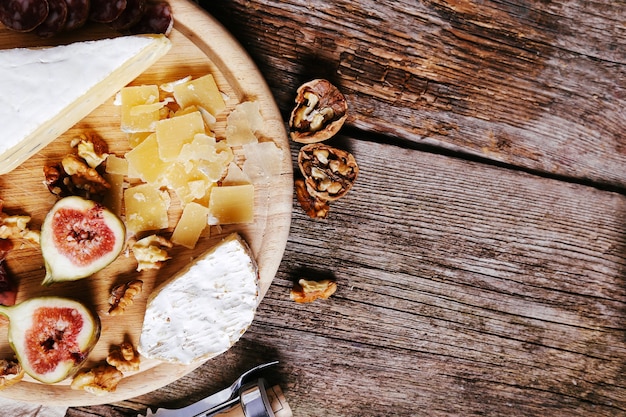 Delicious snacks on wooden board