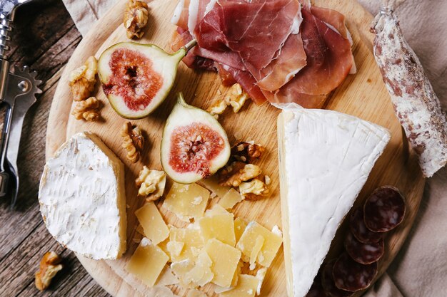 Delicious snacks on wooden board