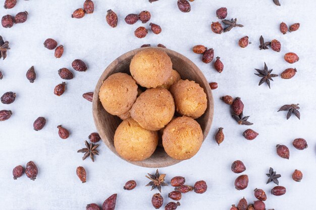 Delicious soft cakes in bowl with rosehips