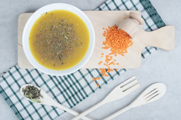 Delicious soup with lentil and spoon on tablecloth