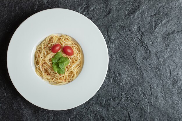 Delicious spaghetti with greens and cherry tomato.