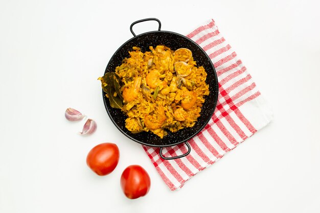 delicious spanish rice in a paella pan on white background