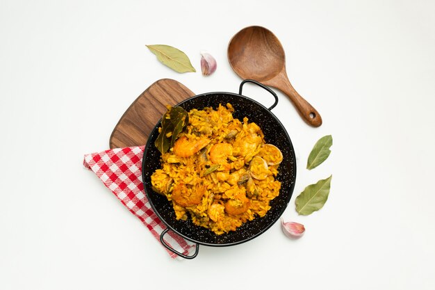 delicious spanish rice in a paella pan on white background