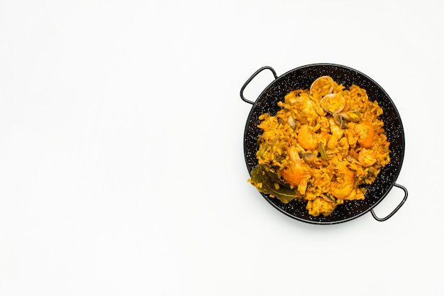 delicious spanish rice in a paella pan on white background