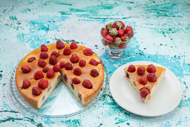 スライスしたおいしいストロベリーケーキと明るい机の上の新鮮な赤いイチゴと一緒に全体のおいしいケーキ、ベリーケーキの甘い焼き