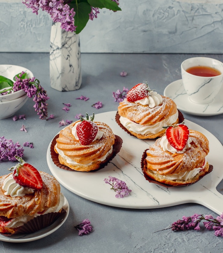 Free Photo delicious strawberry cream puff eclairs on marbles board