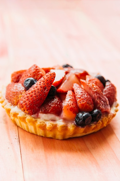 Delicious strawberry tart on wooden backdrop