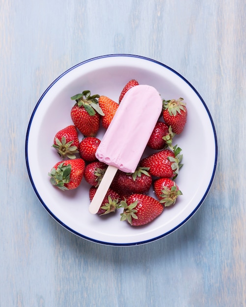 Delicious summer ice cream surrounded by strawberries in a bowl