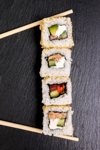 Delicious sushi on black plate