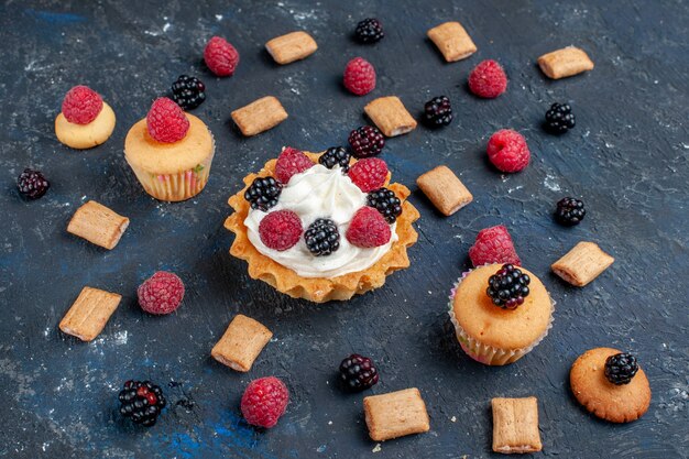 delicious sweet cake with different berries and yummy cream on dark-grey, fruit berry cake biscuit sweet bake