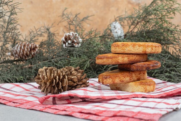 Вкусная сладкая выпечка с рождественскими шишками на скатерти