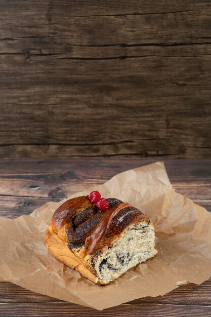 Delicious sweet pastry with chocolate on cooking sheet on wooden surface.