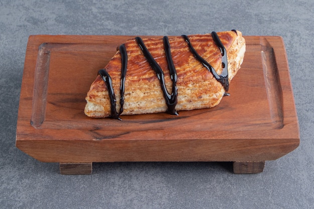 Delicious sweet triangle pastry on a wooden board