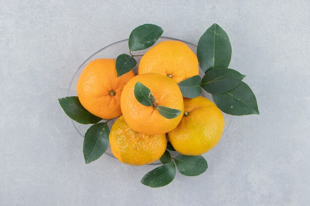 Delicious tangerine fruits on glass plate